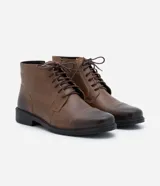 Bota de cuero marrón con caña corta, cierre de cordón y suela negra.