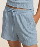 Bermuda color crema de poliéster y elastano, con cintura elástica con lazo y textura chambray.