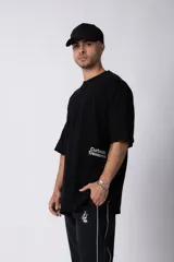 Remera negra oversize de algodón con cuello redondo y mangas cortas. Estampado pequeño en el frente y estampado grande en la espalda con la frase "Curbside Treasure".