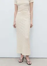 Falda midi color crudo, de tejido texturizado con diseño entallado y cintura elástica.