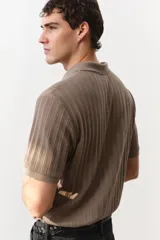Remera polo marrón en punto texturizado de peso medio, de manga corta con cuello, tapeta de botones y bajo recto. Corte ajustado que realza el contorno del cuerpo creando una silueta entallada.