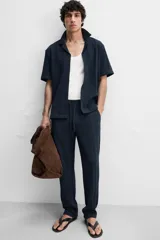 Pantalón azul marino de corte relaxed fit, confeccionado en tejido con mezcla de algodón. Presenta cintura elástica ajustable con cordón, bolsillos frontales y detalle de bolsillo trasero de plastrón.
