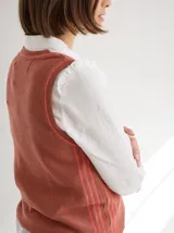 Chaleco tejido color crema con cuello redondo y rayas verticales marrones.