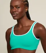 Top deportivo color marrón con breteles anchos y doble tira, copa desmontable, detalles contrastantes en color crema, escote en U delantero y escote en V en la espalda. Confeccionado en microfibra.