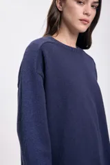 Buzo azul de punto con lurex, de corte holgado y cuello redondo.