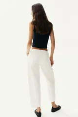 Top negro corto sin mangas en punto suave. Modelo de ajuste ceñido con escote corazón profundo y costura fruncida en el centro del busto.