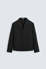 Blazer negro de corte regular, con cuello de solapas de muesca, manga larga con puños abotonados, bolsillos laterales ocultos en la costura de la cadera, bolsillo interior y cierre frontal con botonadura.