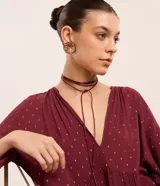 Conjunto de collar de cordón y caravanas con forma de flor con pétalos en capas y detalle en el borde, con baño de oro ligero.