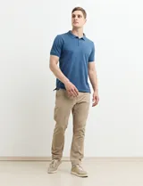 Chomba azul marino con pequeños lunares blancos, cuello clásico con botones y mangas cortas.