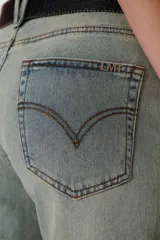 Pantalón de jean celeste de corte semi oxford, con detalles de cuero en pretina y bolsillos.