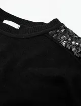 Buzo de tejido de punto color negro, con cuello redondo y mangas largas. Apliques de lentejuelas en los hombros. Marca Q2.