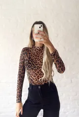 Top de microtul con estampado animal print de leopardo, cuello alto y mangas largas.