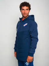 Parka azul con capucha, cierre frontal con cremallera y logo del Club Nacional de Football en el pecho.