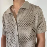 Camisa negra tejida con diseño calado, manga corta y corte regular.