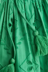 Vestido largo verde con breteles finos y escote en V. Presenta bordados florales y detalles de broderie en todo el vestido. Tiene corte en la cintura y falda con vuelo.