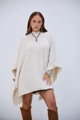 Poncho de punto color crudo, con cuello redondo y diseño holgado.