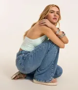 Pantalón de jean wide leg color celeste con bolsillos, trabillas y detalle de tachuelas plateadas.