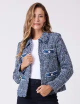Chaqueta de tweed azul con cuello a la base, abertura central y bolsillos delanteros. Presenta puños con aplique de botones perlados y terminación desflecada. Incluye forro interno.