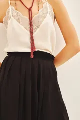 Minifalda negra estilo portafolio con tablas, cintura elastizada y broche metálico.