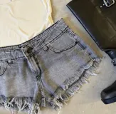 Short de jean gris con efecto desgastado y terminación desflecada.