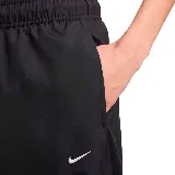 Pantalón deportivo negro de tejido woven con cintura elástica, corte holgado y logo de Nike bordado en blanco en la pierna izquierda.