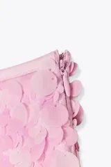 Minifalda rosada cubierta de lentejuelas, con forro interior y cierre lateral oculto.