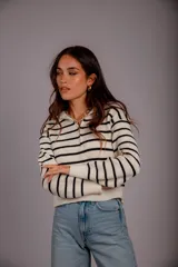 Sweater de punto color beige con rayas horizontales blancas, cuello polo con cierre de cremallera y mangas largas.