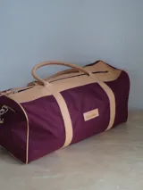 Bolso de lona azul con detalles en cuero marrón, doble asa de mano y correa bandolera ajustable. Incluye un neceser haciendo juego con cierre y logo de caballo bordado.