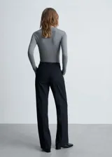 Pantalón de vestir negro de corte recto y tiro medio, con cierre de cremallera y botón, trabillas para cinturón y bolsillos laterales.
