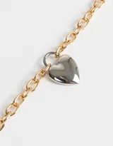 Collar corto dorado con cadena de eslabones gruesos y dije de corazón inflado.