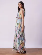 Vestido largo de gasa estampada con flores en tonos celeste, rosa y verde. Tiene cuello halter con abertura en forma de ojal, corte en la cintura con faja plisada y abertura central en la espalda con cierre invisible.