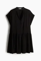Vestido corto negro de tejido arrugado con cuello mao y abertura en V, mangas cortas con doblez, botones forrados y costura fruncida en la cadera.