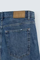 Pantalón de jean gris de corte recto, con cinco bolsillos, efecto lavado y cierre frontal con botones.