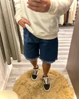 Short de jean azul con terminación desflecada.