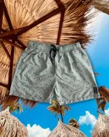 Short de baño celeste con estampado de palmeras en negro, cintura elástica con cordón ajustable y bolsillos laterales.