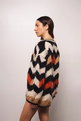 Buzo tejido a mano con lana merino, estilo oversized con diseño de ondas en colores blanco, negro, azul y marrón.