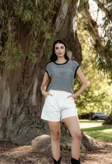 Blusa de hilo tejido a rayas horizontales en tonos gris y negro, de corte suelto y oversize, con cuello redondo y mangas cortas.