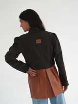 Blazer azul marino corto de lana con cuello solapa y mangas abullonadas.