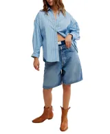Camisa a rayas verticales color crema y marrón, de corte oversize y estilo masculino. Tiene cuello camisero, cierre frontal con botones y canesú en la espalda.