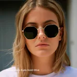 Lentes de sol geométricos con armazón dorado de acero inoxidable y lentes polarizados negros. Cuentan con protección UV400 y tratamiento antirayaduras.