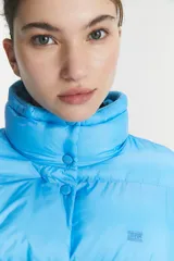 Campera puffer celeste con cuello alto y cierre de botones a presión.