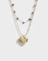Collar corto dorado de doble cadena, una con piedras amatistas y otra con dije de corazón relicario.