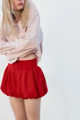 Camisa de popelina a rayas marrones y blancas, con cuello bobo con puntilla y escote pico con lazada. Manga larga con puño y cierre frontal con botones.