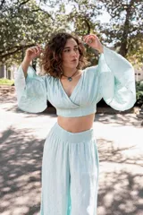 Top celeste con lurex, escote cruzado y mangas anchas acampanadas.