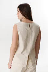 Top sin mangas confeccionado en mezcla de lino y algodón color marrón, con escote en V y pespuntes blancos decorativos en contraste.