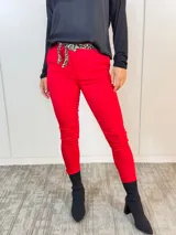 Pantalón rojo de corte Aline con cintura plisada y lazo con estampado animal print.