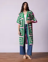 Cardigan largo tejido al crochet con diseño geométrico en verde y rosa. Tiene mangas 3/4 y corte holgado.