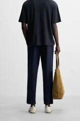 Pantalón azul marino de corte amplio, confeccionado en tejido de mezcla de algodón y lino. Cuenta con cintura elástica ajustable con cordón, bolsillos frontales y bolsillos traseros de vivo.