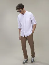 Camisa blanca de lino con cuello mao, manga larga con puños abotonados y bolsillo en el pecho.