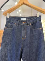 Pantalón de jean Oxford de tiro alto, color azul oscuro. Tiene dos bolsillos redondeados en la cadera y dos bolsillos en la parte trasera. Cierre con botón metálico y cremallera.